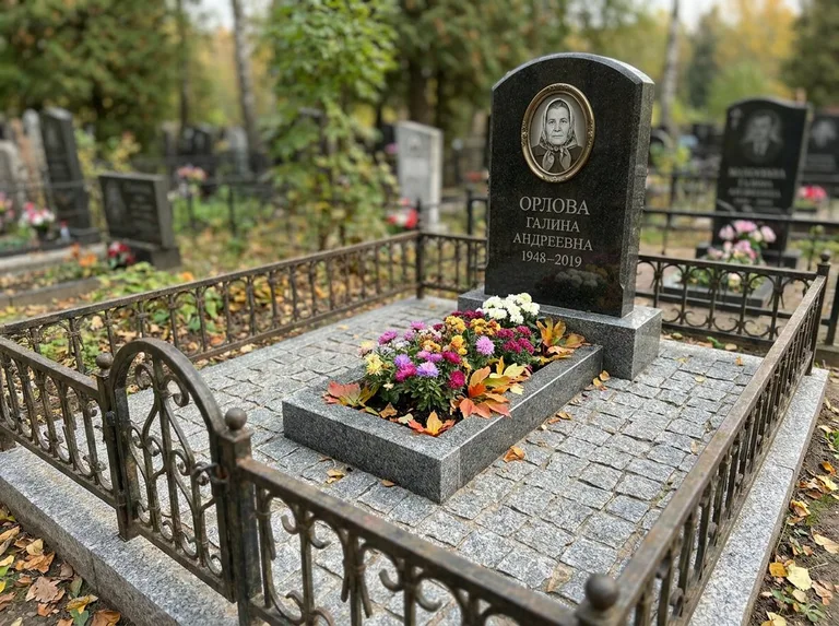 Благоустроенное захоронение с гранитной плиткой, оградой и цветником в Воронеже