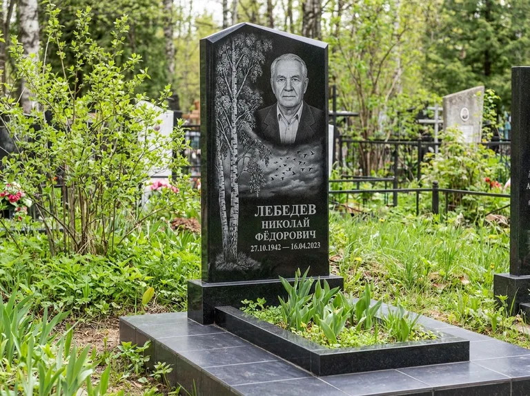 Памятник с гравировкой берёзы: вертикальная стела со скошенным верхом — берёза и стая птиц в небе, гранитный цоколь с тёмной плиткой, работа «Лебедев» в Воронеже