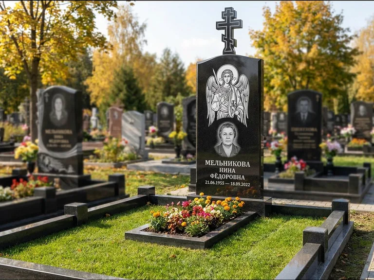 Памятник с гравировкой иконы: округлая стела-медальон с ликом — гравировка Богородицы «Семистрельная», луговые травы и полевые цветы за участком, работа «Гущин» в Воронеже