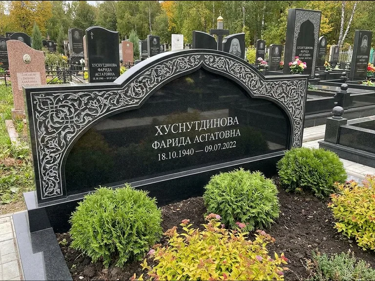 Мусульманский памятник: вытянутая горизонтальная семейная стела с аркой — белая гравировка силуэта мечети с минаретами, участок с декоративными кустами, работа «Зарипова» в Воронеже