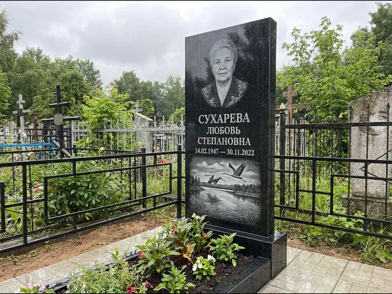 Памятник с гравировкой журавлей — гравировка пары журавлей над гладью озера в нижней части, работа «Сухарева» в Воронеже