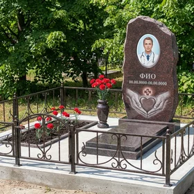 Гранитный памятник врачу в форме скалы с эмблемой врача